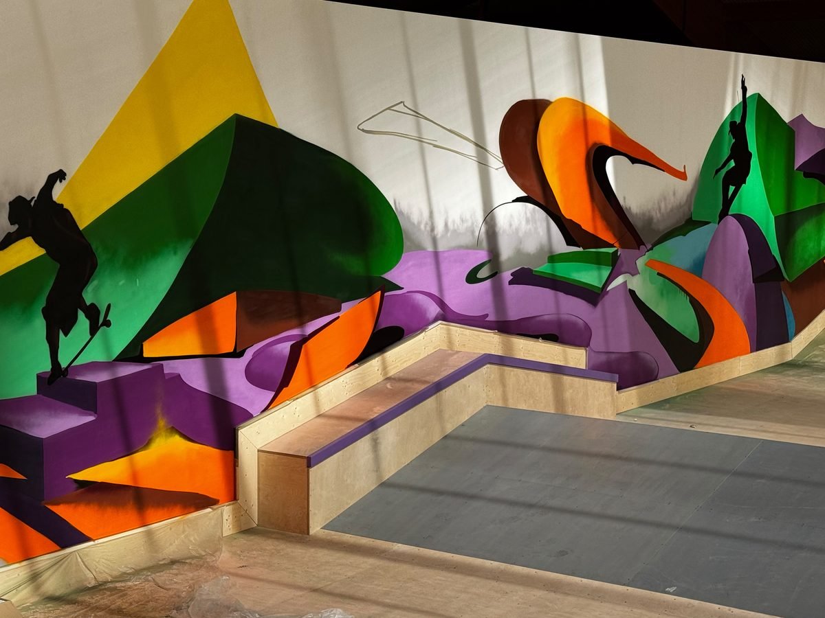 Bemalte Wand mit Skater-Motiven hinter einer Bank